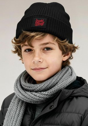 Black ribbed beanie with a red "Little Devil" patch. Grey knitted scarf with a chunky texture. Black puffer jacket with a zip.