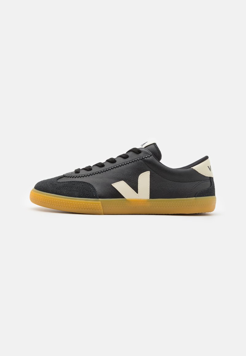 Sapatilhas pretas com um cabedal de couro suave, logo "V" branco e detalhes, design com atacadores e sola de borracha da cor de goma. Estilo baixo, design minimalista.