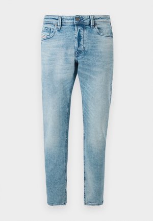 Jeans de denim azul claro com corte slim, apresentando bolsos frontais e fecho de botão. O tecido tem um acabamento suave e texturizado.