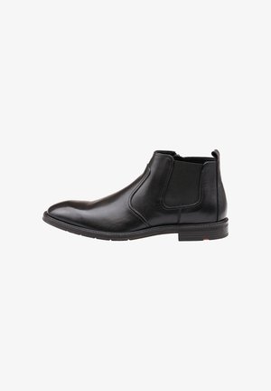Stivale Chelsea in pelle nera con finitura liscia, pannelli laterali elasticizzati, punta affusolata e suola robusta con un accento rosso sul tallone.