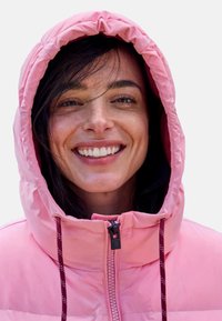 Pinkfarbene Steppjacke mit Kapuze, Frontreißverschluss und Kordelzugdetails. Glatte Textur mit figurbetontem Design, geeignet für kühles Wetter.