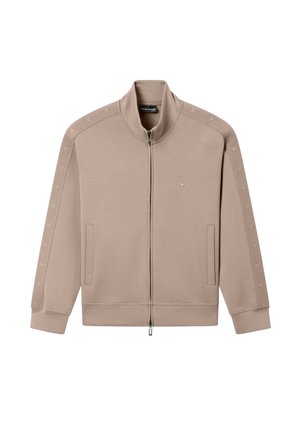 Beige Joggingjacke mit Reißverschluss, hohem Kragen, seitlichen Taschen und Logodetails an Ärmeln und Brust.