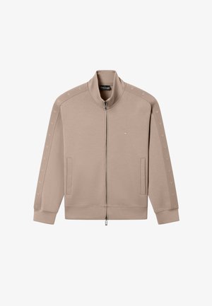 Chaqueta deportiva beige con cremallera, cuello alto, bolsillos laterales y detalles con logo en las mangas y el pecho.