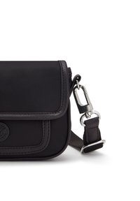 Borsa a tracolla nera in nylon con finitura in pelle, chiusura a pattina, minuteria metallica, tracolla staccabile e dettaglio del logo circolare.