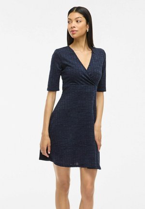 Navy blue wrap dress with short sleeves, textured grid pattern, V-neckline, and flared hem, made from a lightweight fabric.