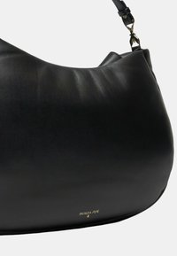 Borsa a spalla in pelle nera con una forma morbida, caratterizzata da un accento con logo dorato e dettagli con tracolla regolabile. Texture liscia con cuciture minime.