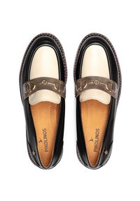 Mocasines de cuero negro y crema con una correa marrón que presenta acentos dorados. El zapato tiene una punta redondeada y una suela texturizada con costuras rojas.