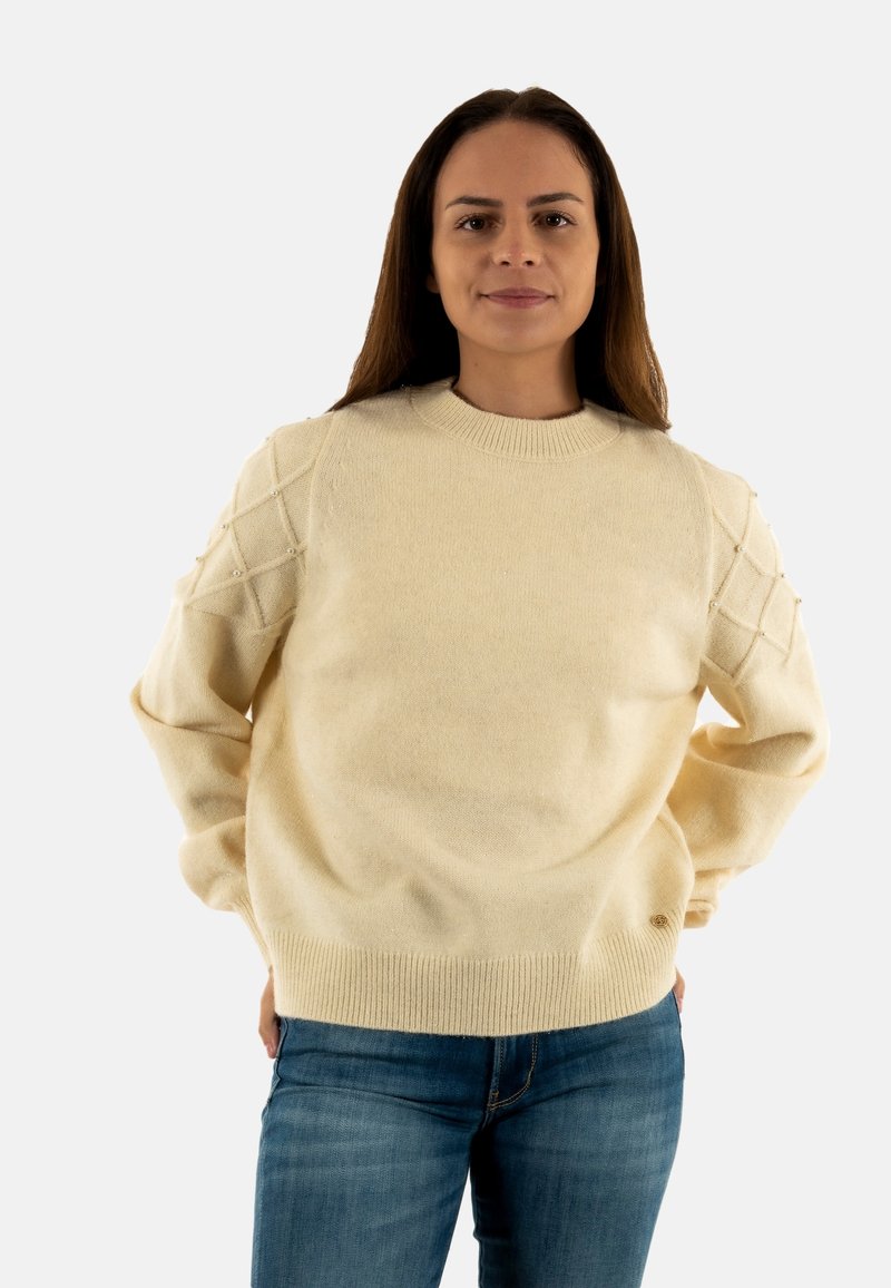 Maglione lavorato a maglia color crema con motivi a rombi testurizzati sulle maniche, orlo a costine e scollatura rotonda, realizzato in un materiale morbido e caldo.