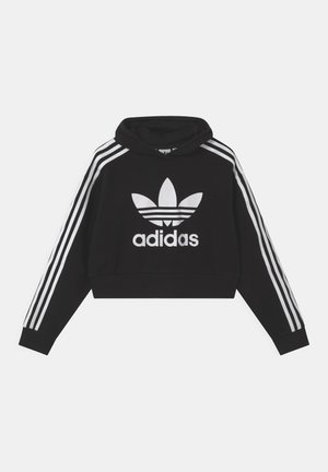 Czarna krótka bluza z kapturem z białym logo trefoil Adidas na klatce piersiowej oraz trzema białymi paskami biegnącymi wzdłuż obu rękawów.