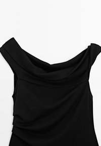 Schwarzes, schulterfreies Kleid mit drapiertem Stoff, das weiche Linien und eine glatte Textur aufweist. Keine sichtbaren Beschläge oder Muster.