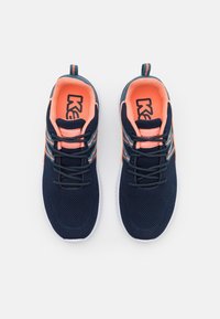 Marinblå mesh-sneakers med orange detaljer. Har en strukturerad ovandel, snörning och en kontrasterande vit sula. Logotyp synlig på tungan.