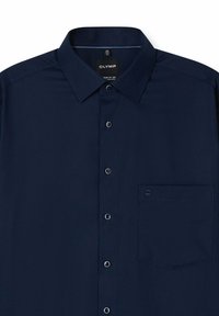 Marineblaue Hemdbluse mit Standardkragen, strukturierter Stoff und einer linken Brusttasche; mit kontrastierenden Knöpfen und dezentem Markenlogo.