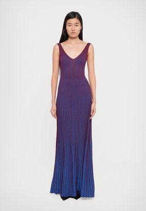 Robe longue en tissu côtelé aux teintes violettes et bleues avec des rayures verticales. Elle présente un décolleté en V profond et une silhouette ajustée.