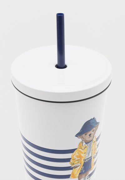 Λευκό φλιτζάνι με μπλε οριζόντιες ρίγες, καπάκι με μπλε καλαμάκι και εικόνα μιας αρκούδας με κίτρινο αδιάβροχο και μπλε καπέλο.