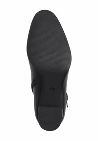 Semelle de chaussure formelle noire avec un dessous texturé antidérapant et une fermeture éclair visible sur le côté.