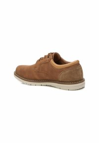 Zapato de cuero marrón con cordones, con un upper texturizado, acentos lisos y una suela acolchada. Presenta costuras de contraste y un diseño robusto.