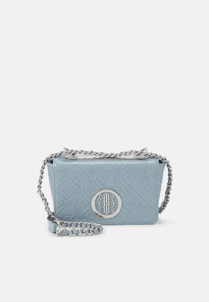 Jasnoniebieska pikowana torebka na ramię z naturalnej skóry z srebrnym łańcuszkiem i okrągłym srebrnym logo na przodzie.