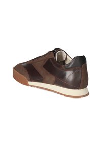 Brown leather and suede sneaker with a rubber sole, rounded toe, and contrasting dark accents. Features lace-up closure and textured panels.