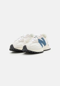 Sneaker bianche con accenti blu, parte superiore in suede e tessuto, punta tondeggiante, suola in gomma nera a contrasto e lacci bianchi piatti.