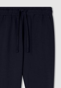 Granatowe spodnie dresowe z elastycznym pasem z sznurkiem i bocznymi kieszeniami, wykonane z miękkiej bawełny.