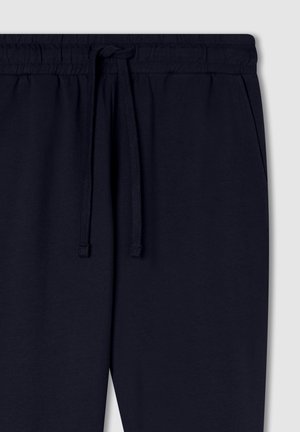 Granatowe spodnie dresowe z elastycznym pasem z sznurkiem i bocznymi kieszeniami, wykonane z miękkiej bawełny.