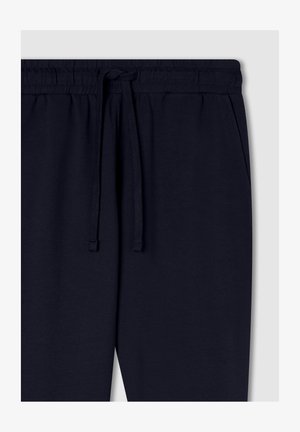 Granatowe spodnie dresowe z elastycznym pasem z sznurkiem i bocznymi kieszeniami, wykonane z miękkiej bawełny.