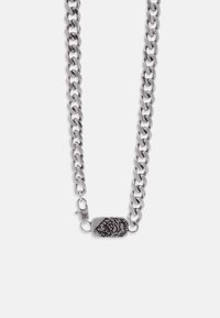 Ασημένιο κολιέ με αλυσίδα από χοντρές, διασυνδεδεμένες συνδέσεις και ένα ορθογώνιο μενταγιόν χαραγμένο με σχέδιο κεφαλής τίγρης.