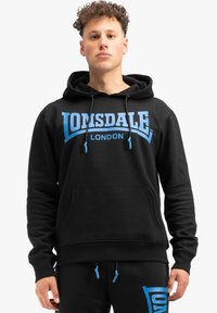 Zwarte hoodie van een katoenmix met blauwe "Lonsdale London" print op de voorkant. Heeft een kangoeroezak en een trekkoord voor de capuchon.