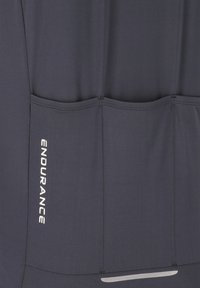 Débardeur de sport gris foncé à texture lisse, doté de trois poches arrière et d'un accent réfléchissant en bas. Marquage sur le côté.