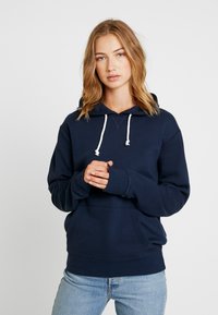 Navy blue hoodie made of cotton blend, featuring a kangaroo pocket, ribbed cuffs, and drawstrings with white accents. Simple, casual design.