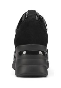 Scarpa sportiva nera con tomaia in suede testurizzato, dettagli in vernice lucida e tallone imbottito, dotata di una suola spessa con un inserto traslucido.