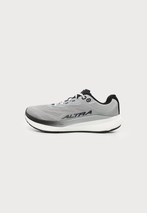 Zapatilla de running Altra gris y negra con suela blanca y parte superior de malla, mostrada en perfil lateral sobre fondo blanco.