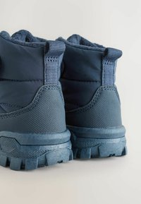 Navy wasserdichte Stiefel mit strukturierten Gummisohlen, gepolstertem Knöchelstütz und einer Schlaufe zum einfachen Anziehen. Verstärkte Nähte sind ebenfalls enthalten.