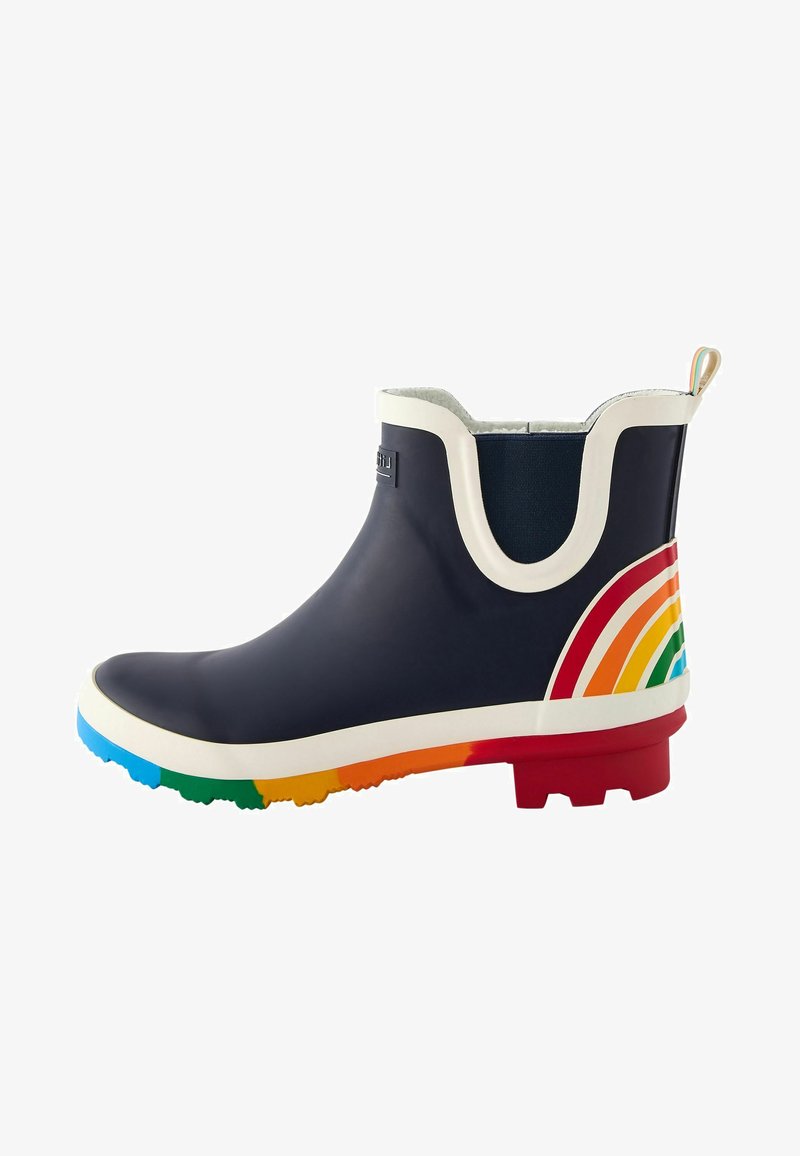 Botte en caoutchouc marine avec une bordure blanche et un accent arc-en-ciel sur le talon. Texture lisse, semelle colorée et panneaux latéraux élastiques.