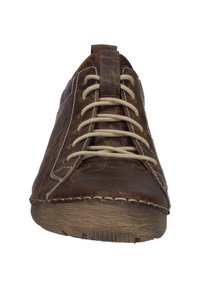 Chaussure décontractée en cuir marron avec des coutures marquées, des lacets plats et une semelle en caoutchouc texturée. Elle présente un bout arrondi et une languette à l'arrière.
