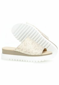 Beige instap sandalen met een getextureerd slangenprint bovenwerk en een brede opening. Voorzien van een dikke witte zool met ribbels voor extra grip.