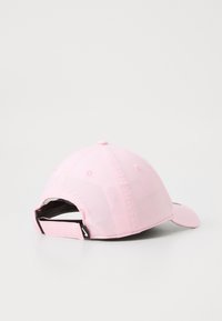 Lys rosa baseball cap med sort justerbar rem og lille hvidt logo på remmen, vist fra bagsiden på hvid baggrund.