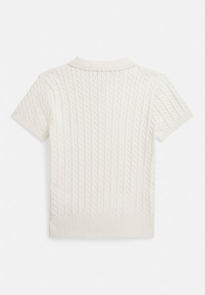 Polo à manches courtes de couleur blanc cassé, présentant une texture en tricot torsadé, un col côtelé et des motifs verticaux discrets sur tout le tissu.