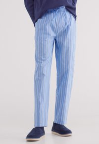 Blauwe en witte gestreepte pyjamabroek met een trekkoord in de taille, gemaakt van lichtgewicht katoen en met een relaxte pasvorm. Draag het met donkere pantoffels.