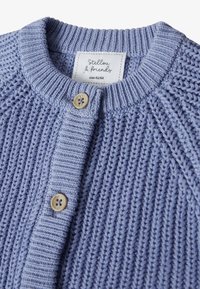 Blauer gestrickter Cardigan mit Rippkragen, ausgestattet mit zwei hellen Holzknöpfen und einem Etikett mit der Aufschrift "Stellou & Friends", Größe 62/68.