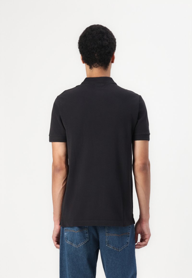 Camisa polo negra con cuello, mangas cortas y bajo recto, fabricada en una suave mezcla de algodón.