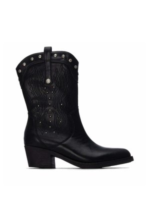 Bota de vaquero de cuero negro con costuras decorativas, tachuelas plateadas alrededor de la parte superior y un tacón medio apilado.