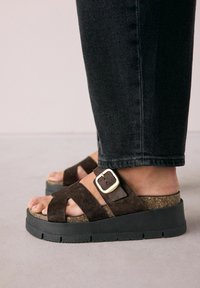 Tamno smeđi aksamitni platform sandali s plutastom srednjom potplatkom i crnom gumenom potplatom, s detaljem zlatne kopče na remenu za stopalo.