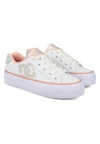 Hvit sneaker med rosa detaljer, laget av syntetisk materiale. Har et low-top design, rund tå, flate snørebånd og en hevet, teksturert såle.