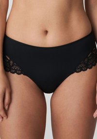 Czarne wysokie majtki wykonane z gładkiego materiału, z falbaniastym koronkowym wykończeniem po bokach. Miękka faktura z elastycznym pasem.