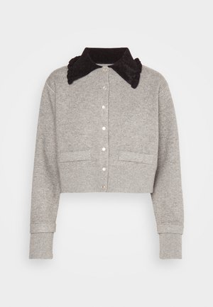 Šedý zkrácený kardigan z měkké tkaniny s černým volánkovým límcem, který má knoflíkové uzávěry a dvě přední kapsy.