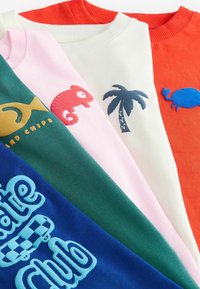 Viisi crewneck-hupparia eri väreissä: vihreä, vaaleanpunainen, valkoinen, punainen ja sininen; joissa on leikkisiä brodeerauksia kontrastiväreissä.