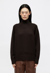 Maglione a collo alto marrone scuro con texture a coste, caratterizzato da una vestibilità rilassata, spalle cadenti e ampi rib cuff e orlo.