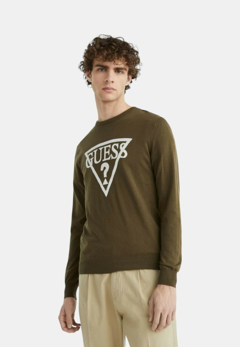 Pullover verde oliva in cotone, con un design del logo triangolare bianco e il testo "GUESS" con un punto interrogativo al centro.