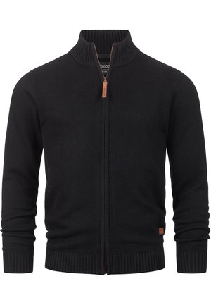 Crna pletena zip-up kardigan s visokim ovratnikom, rebrastim manžetama i rubom. Uključuje smeđu kožnu ručku za zatvarač i oznaku s logotipom.